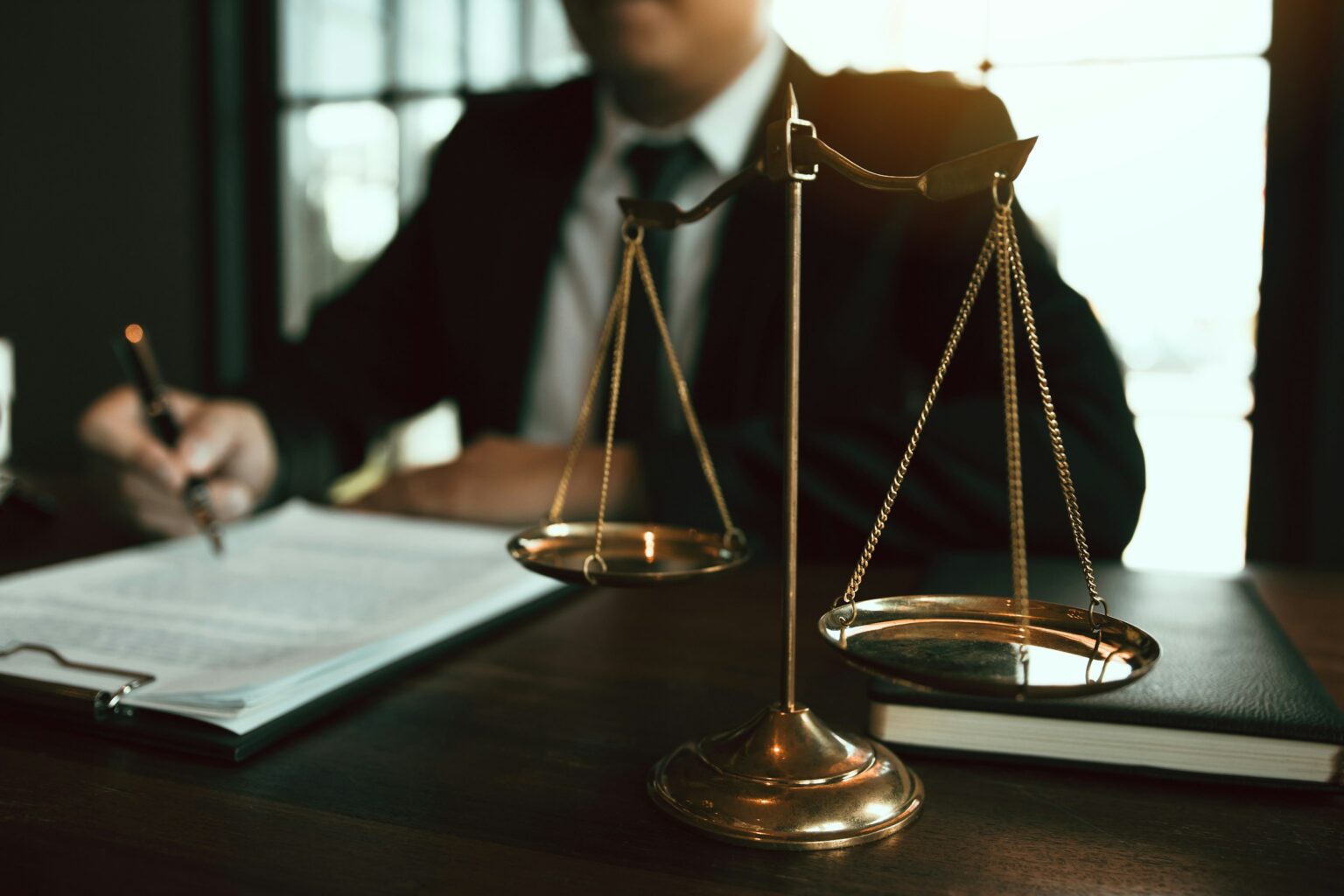 Attorney reviewing a contract beside the scales of justice
